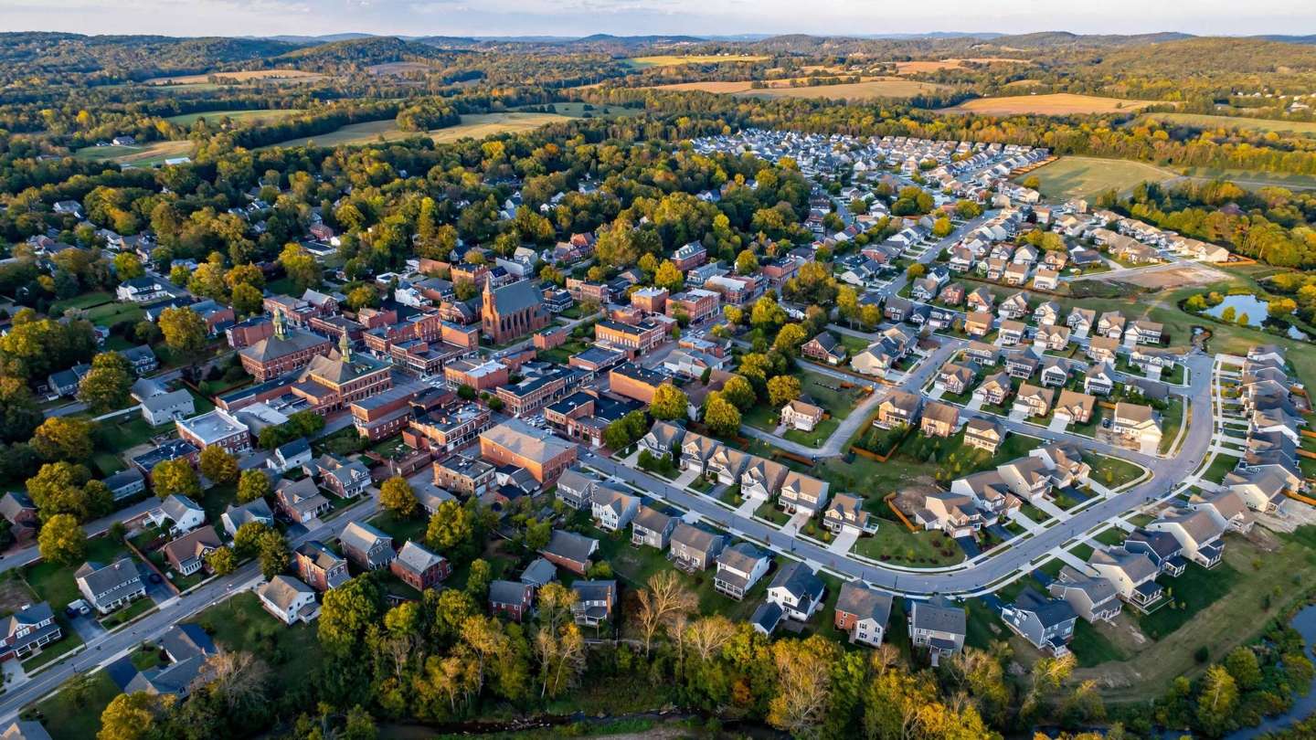 Aerial view where the historic brick borough of Red Lion meets newer suburban subdivisions at the town edge